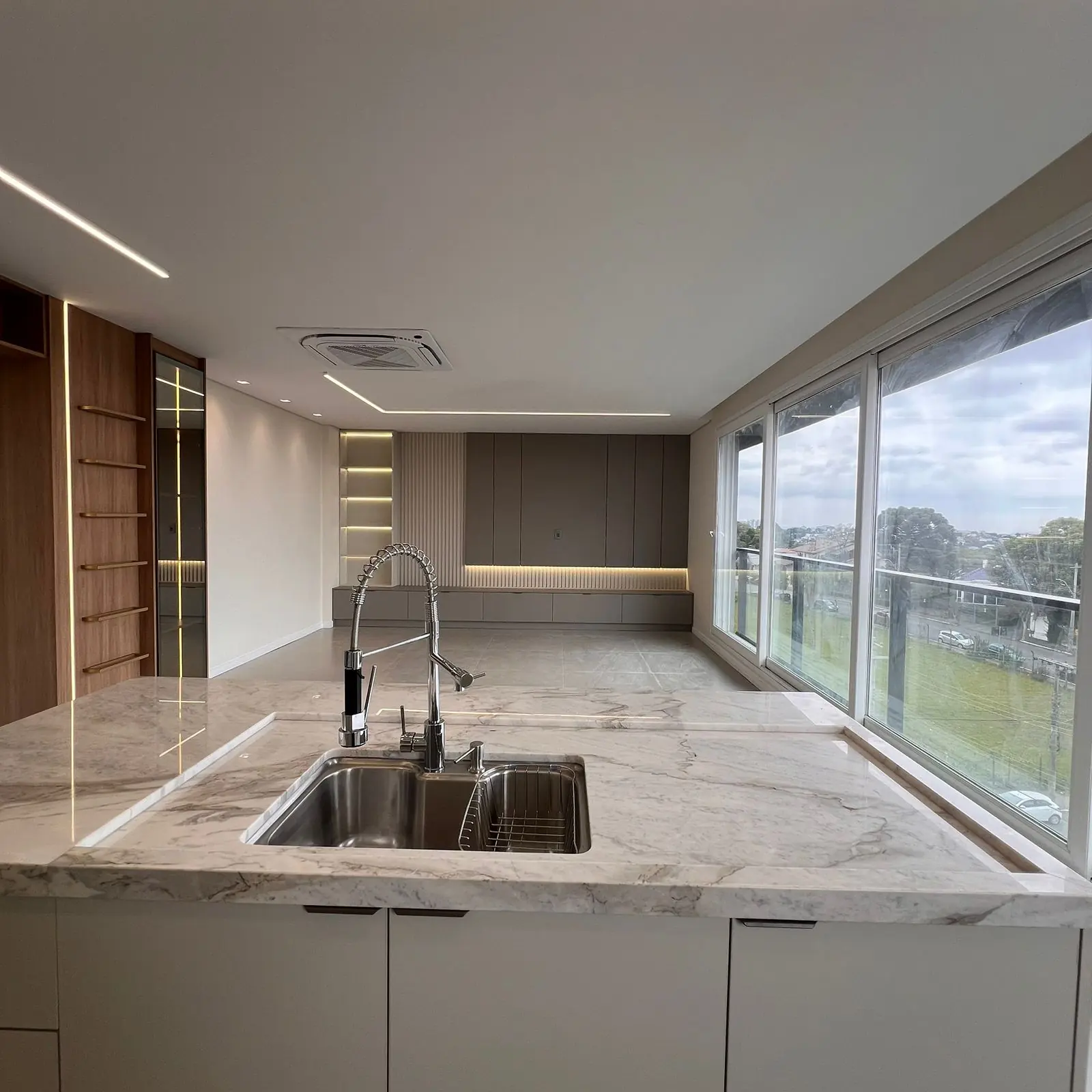 Cozinha planejada DOMOV com ilha em mármore, luz natural ampla e marcenaria clara